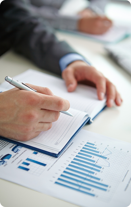 Professional reviewing analytics reports and taking notes